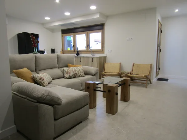 Salon de Casa La Alcoholera con sofa y cocina al fondo
